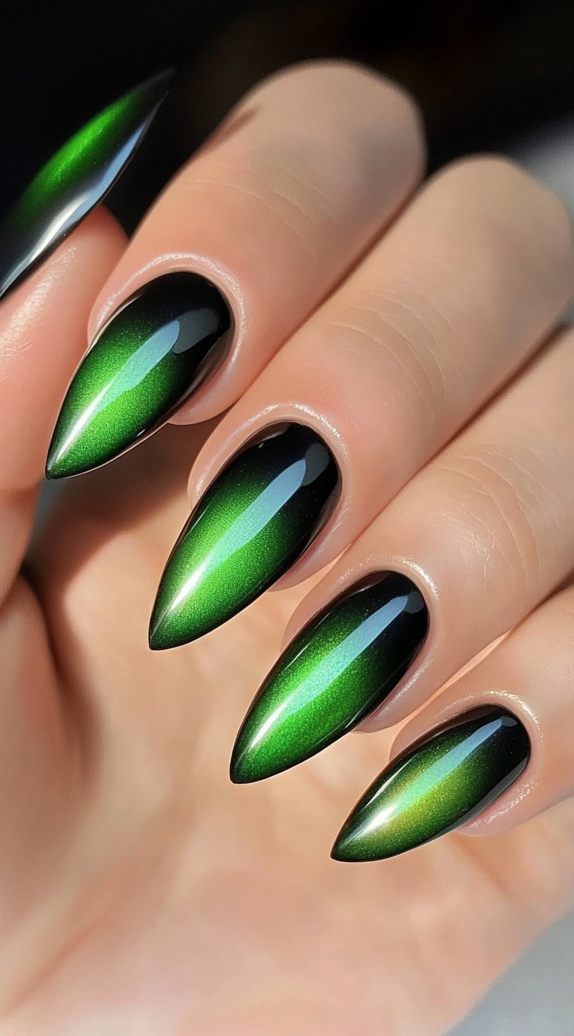 Dramatic almond nails with a high-gloss emerald green and black chrome finish for a bold, modern edge.