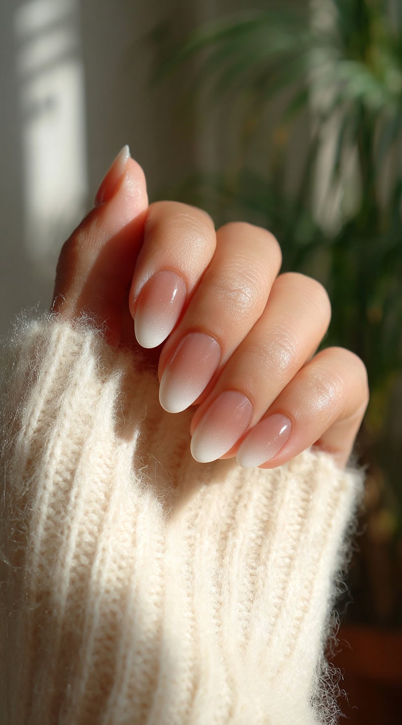 Almond-shaped nails featuring a seamless gradient from soft pink at the base to white at the tips.