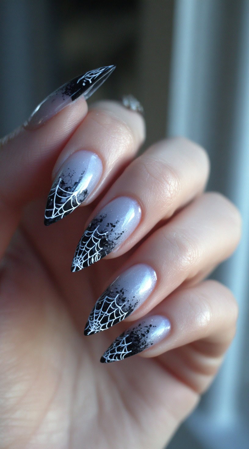 A hand with icy gray stiletto nails that fade into black spiderweb tips.
