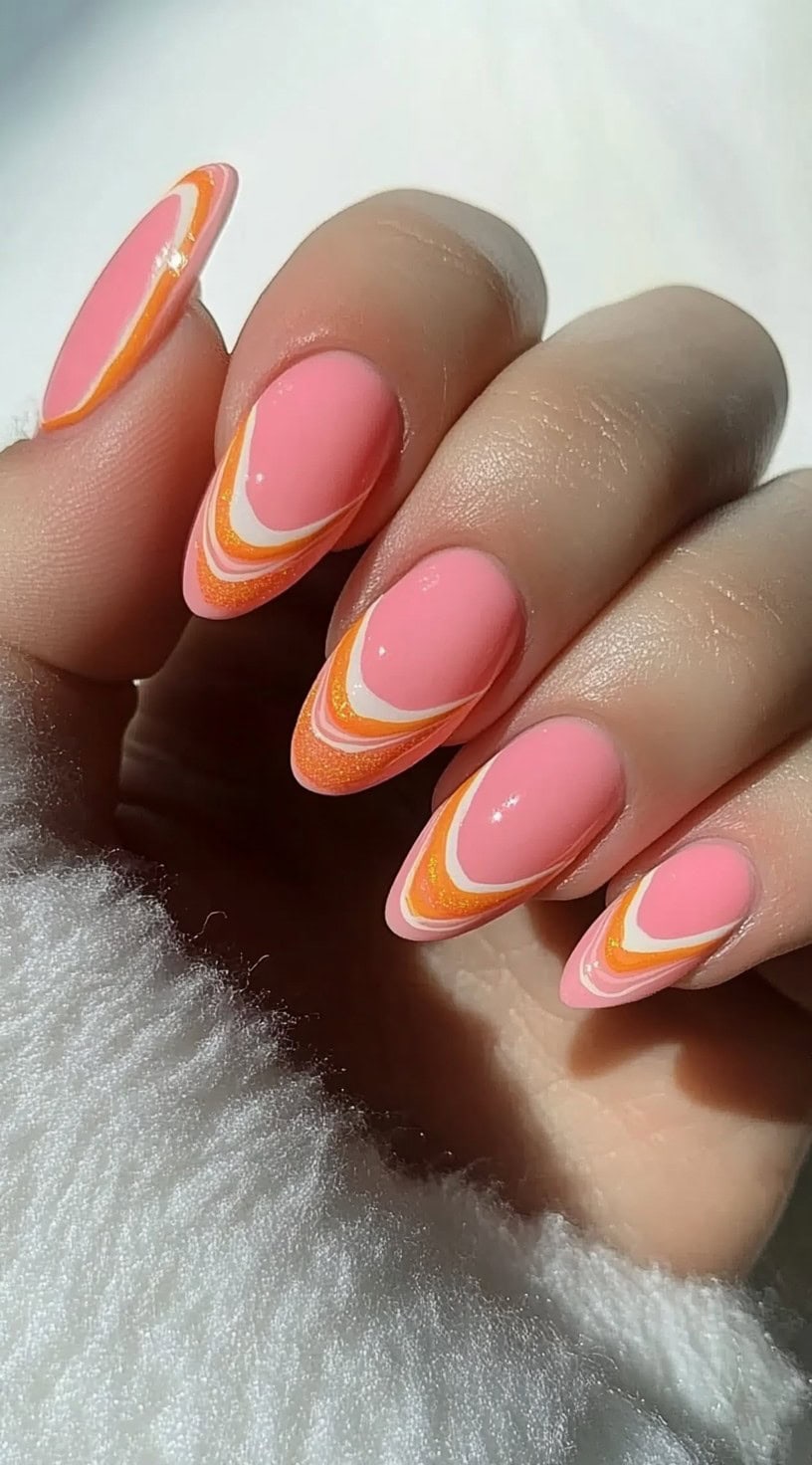Almond-shaped nails with soft pink bases and layered orange and white arched French tips.