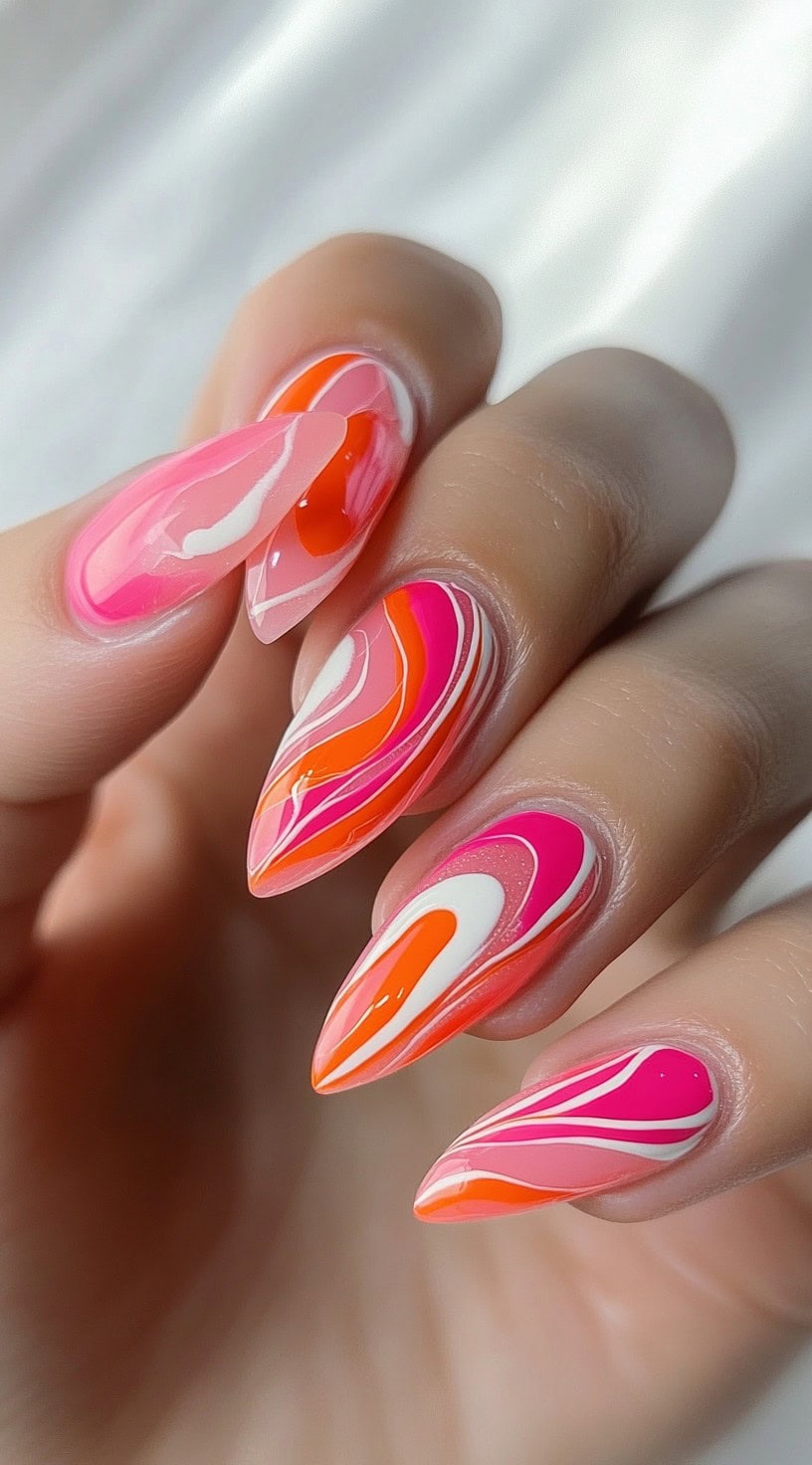 Almond-shaped nails decorated with pink, orange, white, and red psychedelic swirl designs on a glossy base.