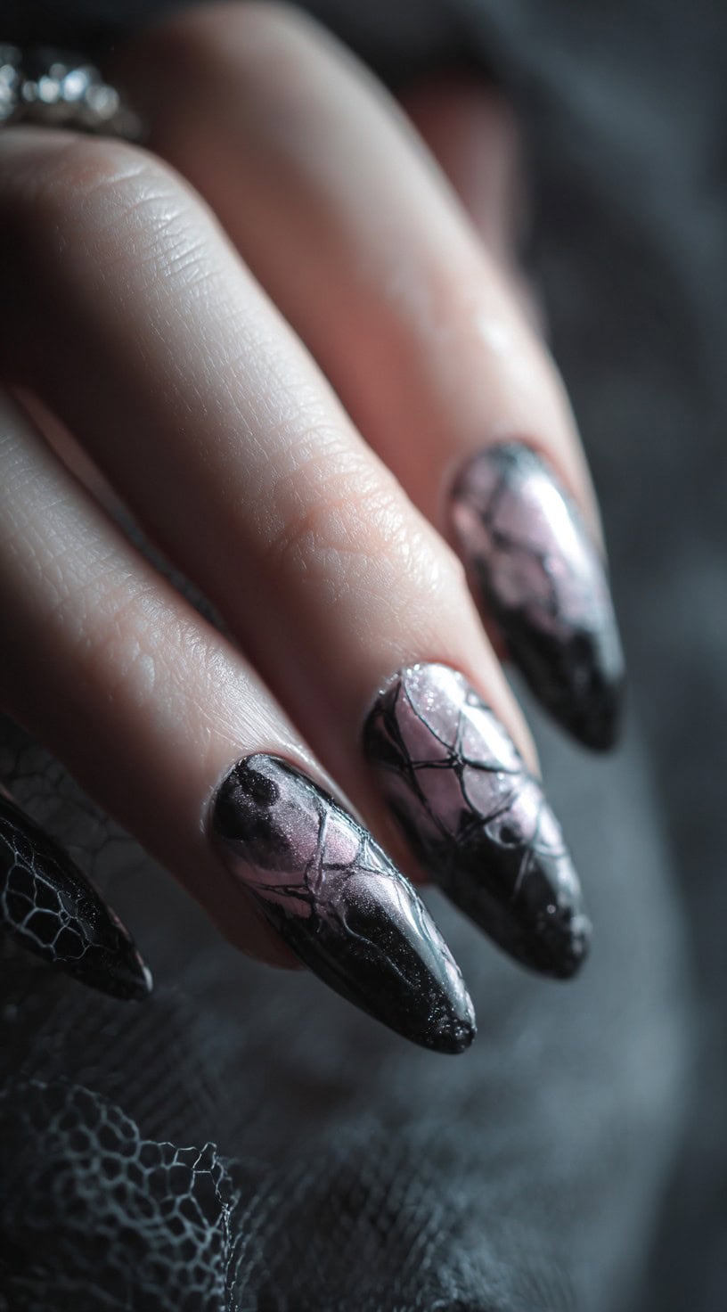 Almond-shaped nails with silvery mauve chrome bases overlaid with intricate black web-like lines.